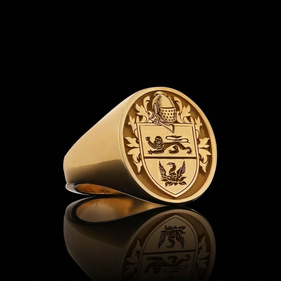 Gold signet ring engraved with a coat of arms beneath a knight's helm